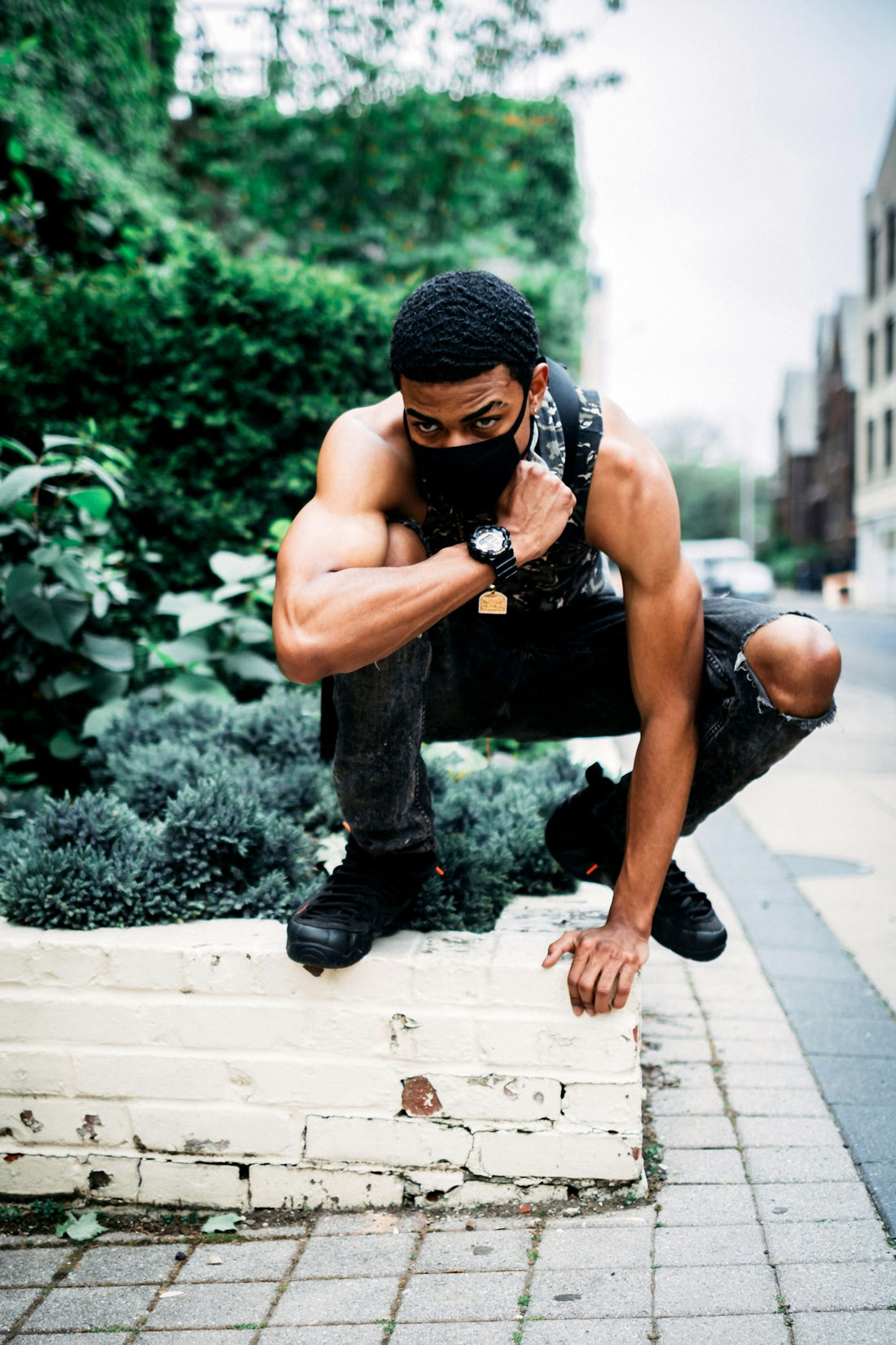 man squatting on concrete wall