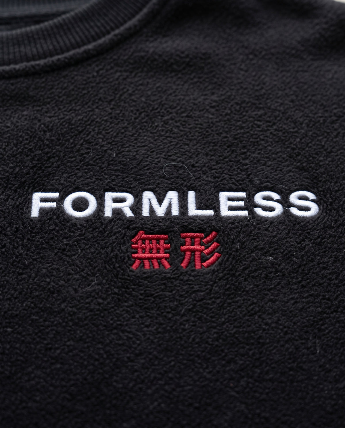Close-up of the FORMLESS 無形 embroidered logo on the black crewneck