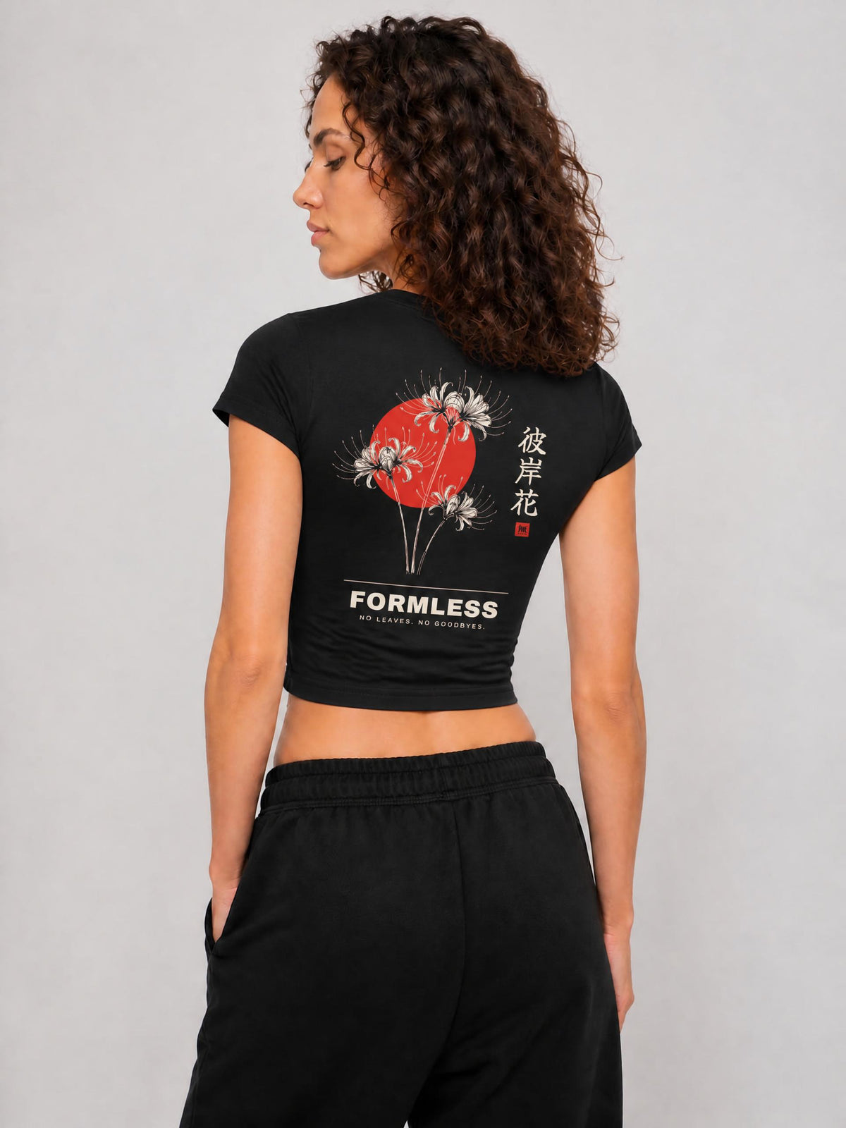 HIGANBANA women's cropped baby tee in Black, worn by a model, back view with red spider lily and red sun print | Formless