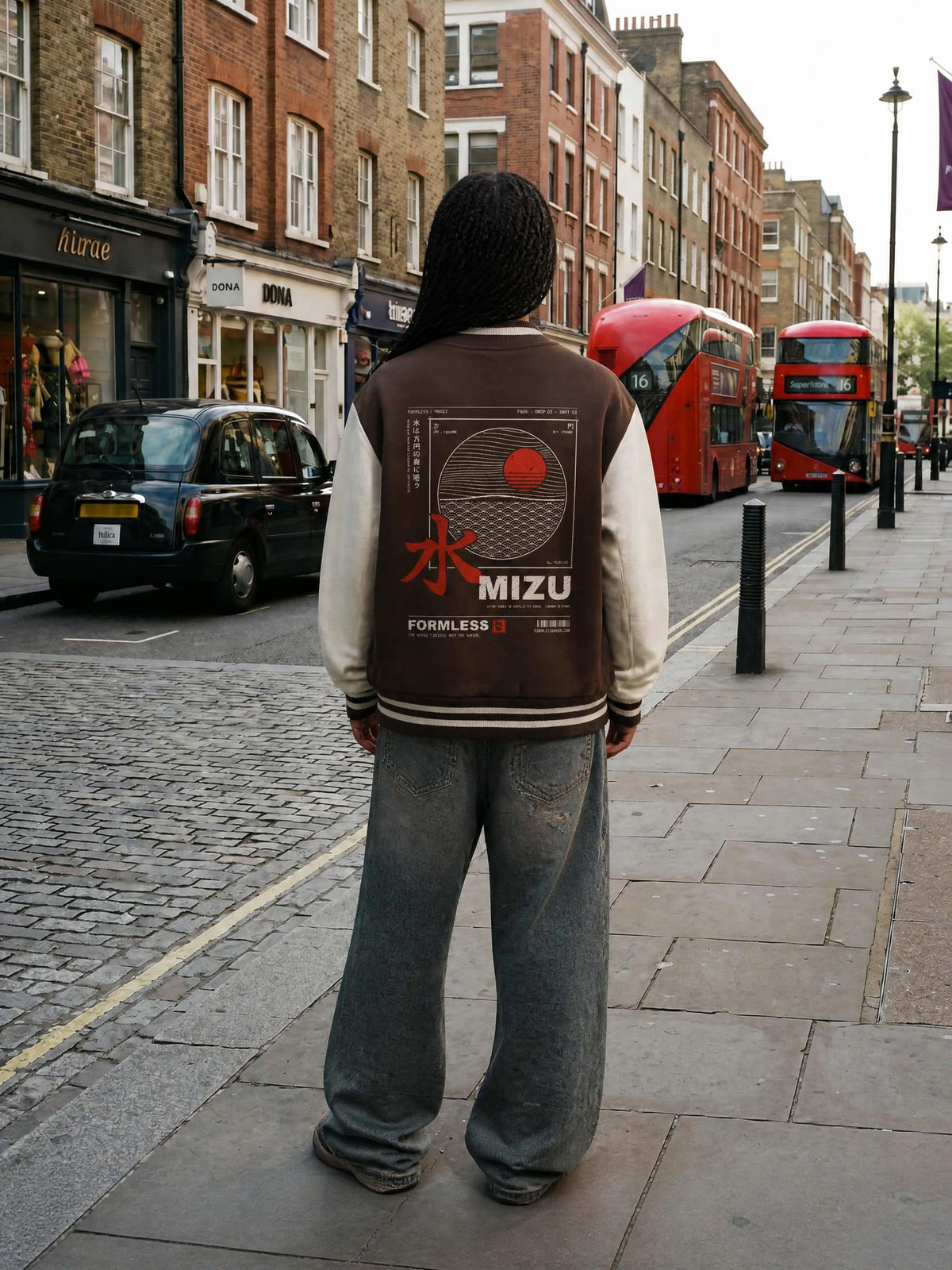 MIZU two-tone varsity jacket in coffee with white sleeves worn by a model on a city street, back view with brush 水, seigaiha waves and sun print | Formless