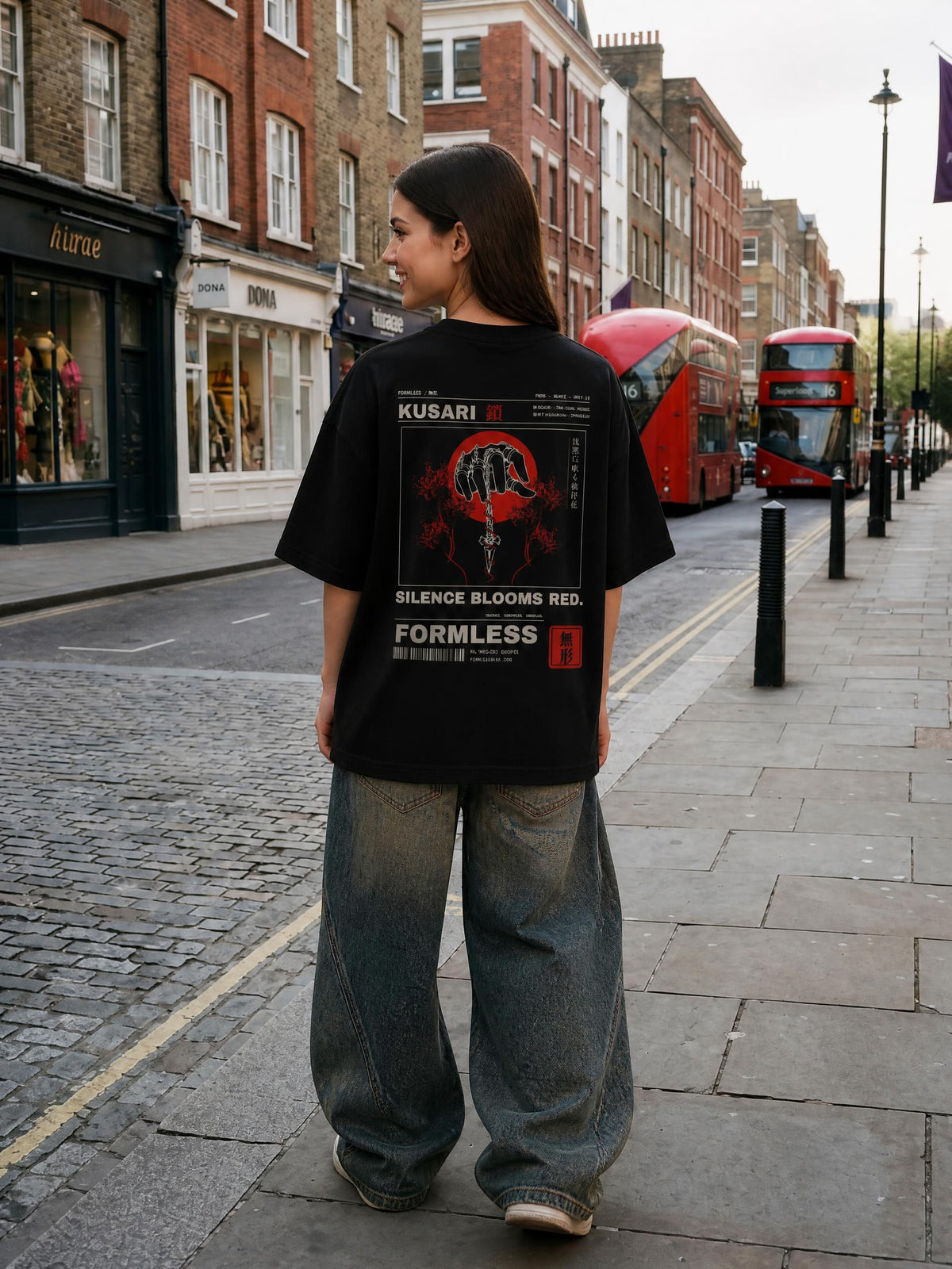 KUSARI heavyweight boxy tee in Black worn by a model on a city street, back view with chained hand, dagger, red sun and spider lily print | Formless