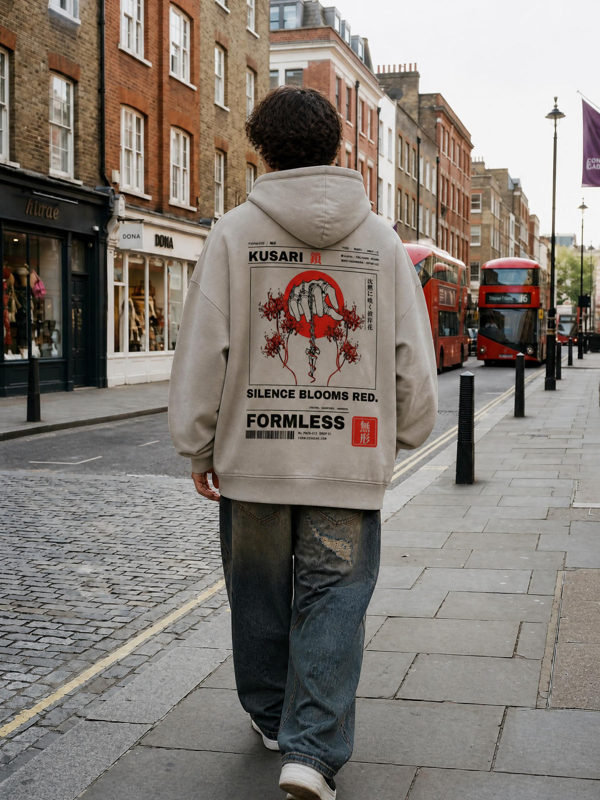 KUSARI heavyweight boxy hoodie in Medium Gray worn by a model on a city street, back view with chained hand, dagger, red sun and spider lily print | Formless