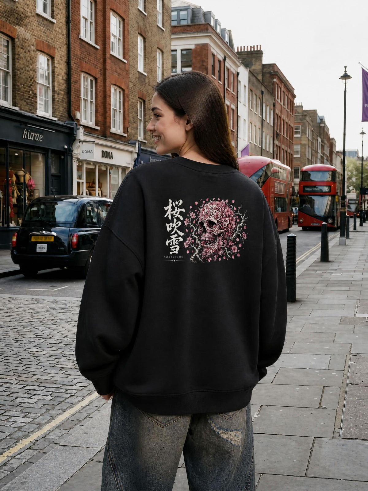 SAKURA FUBUKI 桜吹雪 distressed sweatshirt in Black worn by a model on a city street, back view with cherry blossom skull and 桜吹雪 print | Formless